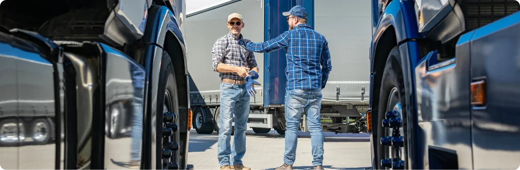 Two men talking beside a truck